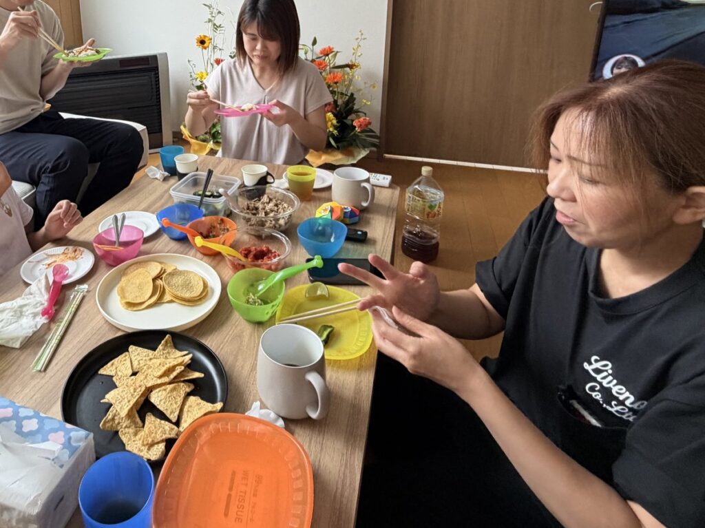 テーブルを囲んでタコスを食べる人たち