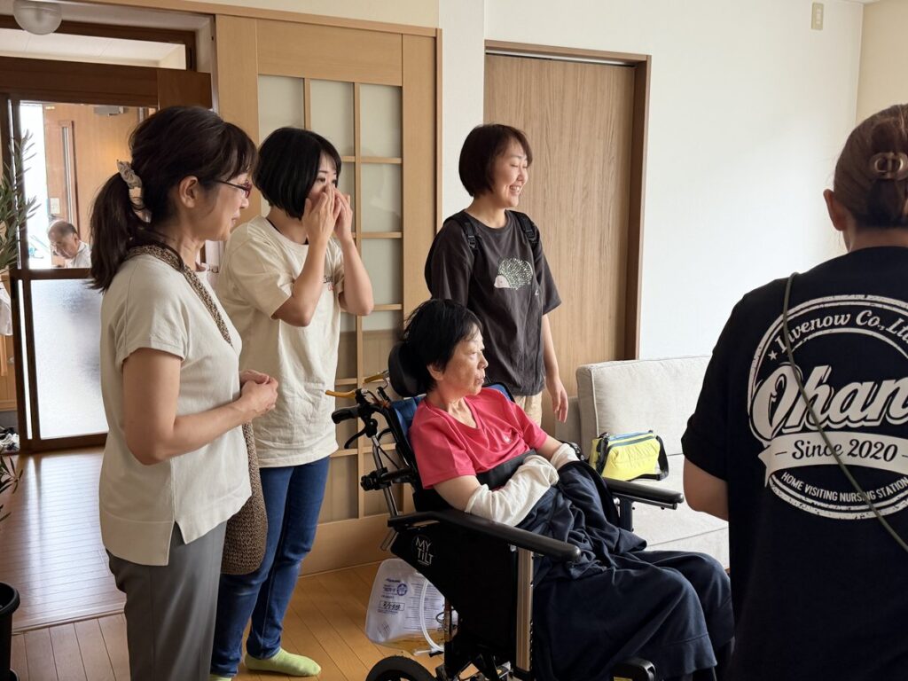 リビングで車椅子の方を囲んで笑い合う人たち