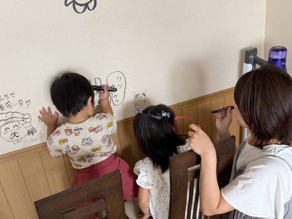 壁に絵を描く子どもの手元